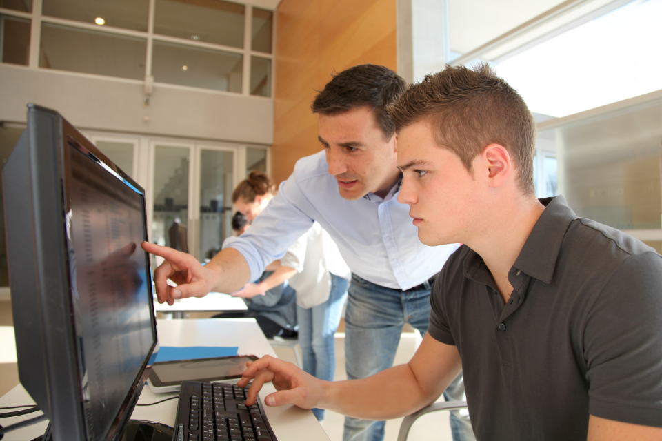 student with mentor looking at computer